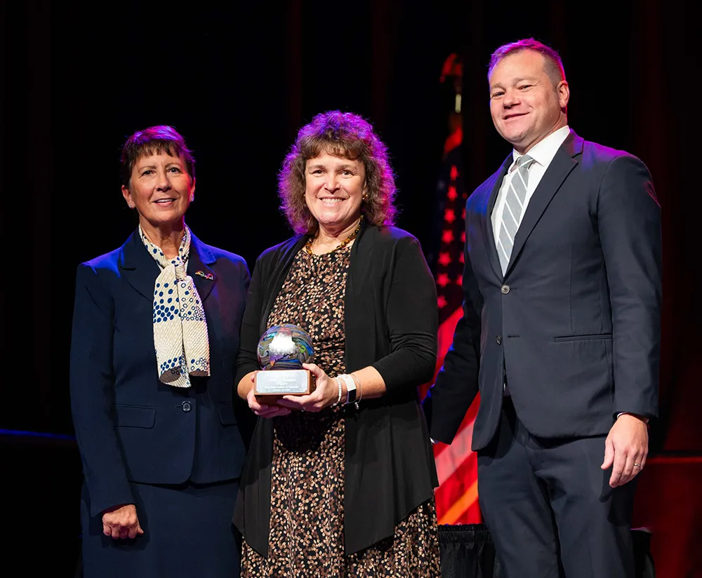 photo of retiring president laurie lachance receiving award on stage with maine state chamber of commerce officials