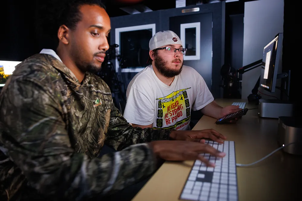 Two students working in the digital media lab at Thomas College