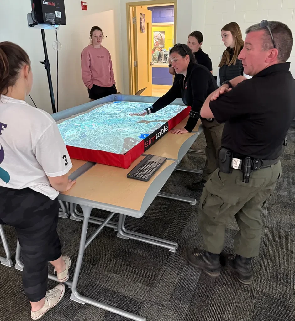 Students receive hands-on academic experience reviewing a simtable operation with Forest Ranger instructors