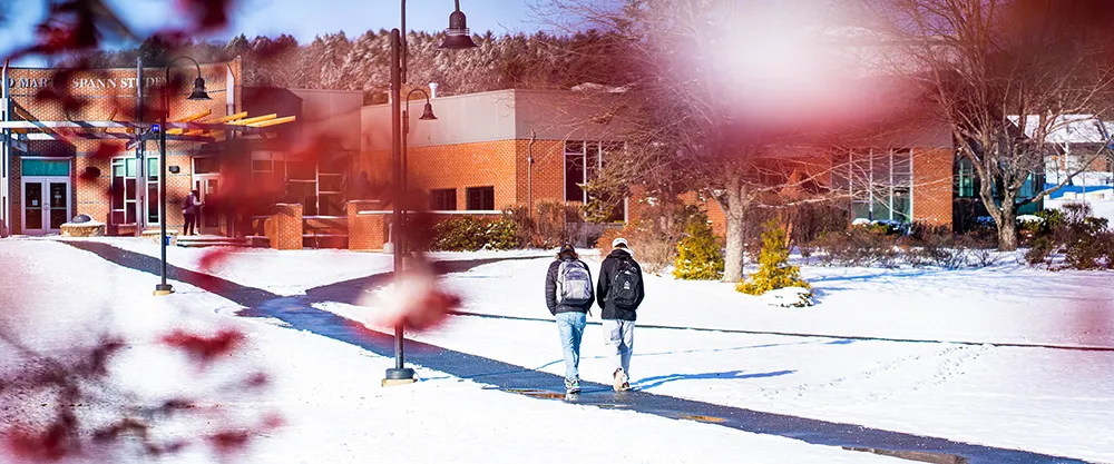 Winter Open House 2024: Two students walk along a paved path on campus