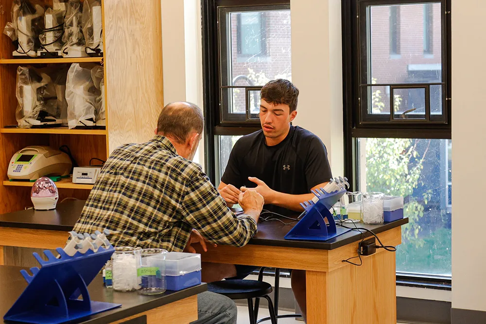 A student works in the lab with an adjunct professor
