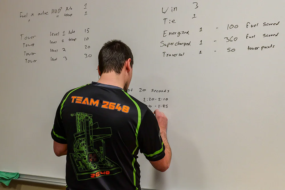 Thomas College Hosts First NASA-Supported Robotics Event for Maine Students: Student at Whiteboard Noting Times
