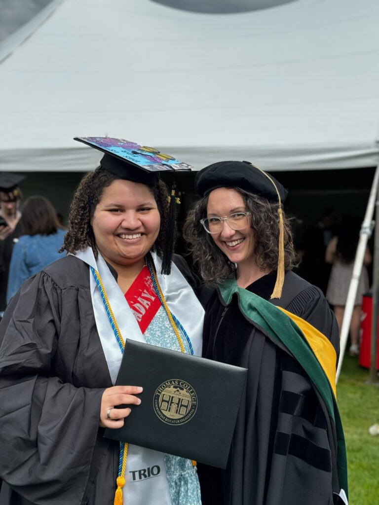 TRIO graduate at Commencement with her professor holding up her diploma