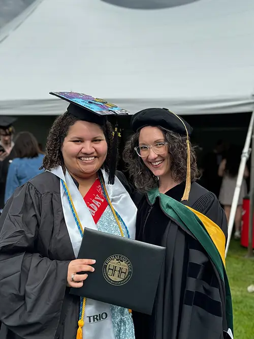 TRIO graduate at Commencement with her professor holding up her diploma