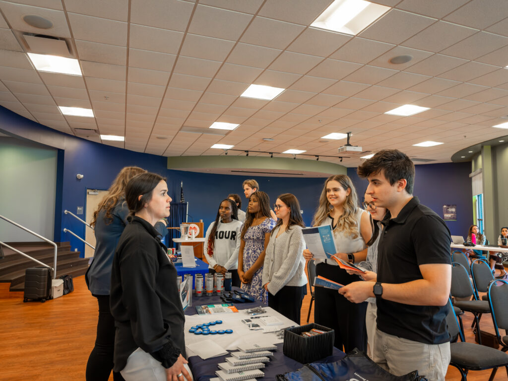 Accounting staff chat with a Thomas College student at accounting firm night