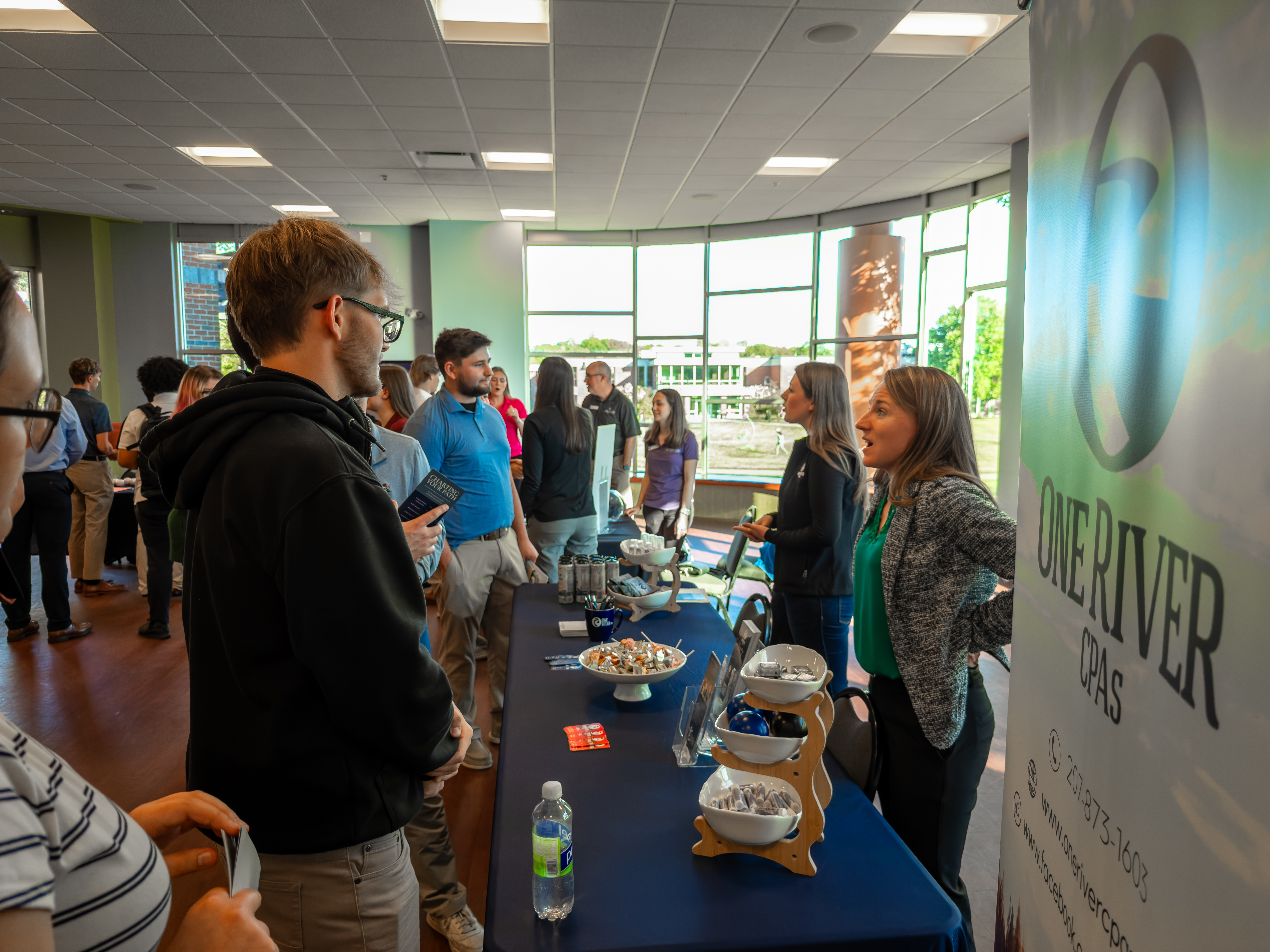 Thomas College students chatting with an accounting firm staff member during accounting firm night at Thomas College