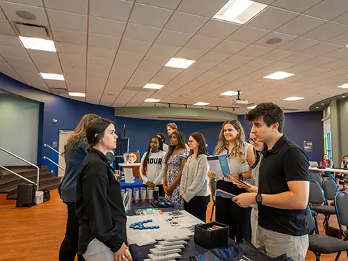 Accounting staff chat with a Thomas College student at accounting firm night