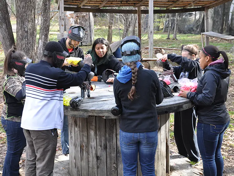 Thomas College students prepping their paintball equipment with paint pellets