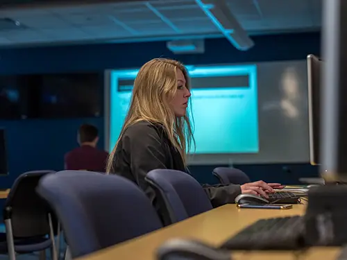 Female graduate student working in a classroom; Thomas College Awarded $3 Million Grant to Build Artificial Intelligence Integration